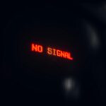 A red LED display indicating 'No Signal' in a dark setting, conveying a tech warning.
